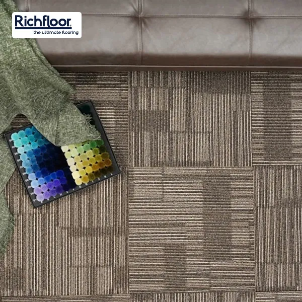 Bề mặt thảm tấm nâu vàng được xử lý chống bám bẩn, giúp duy trì vẻ sạch sẽ lâu dài